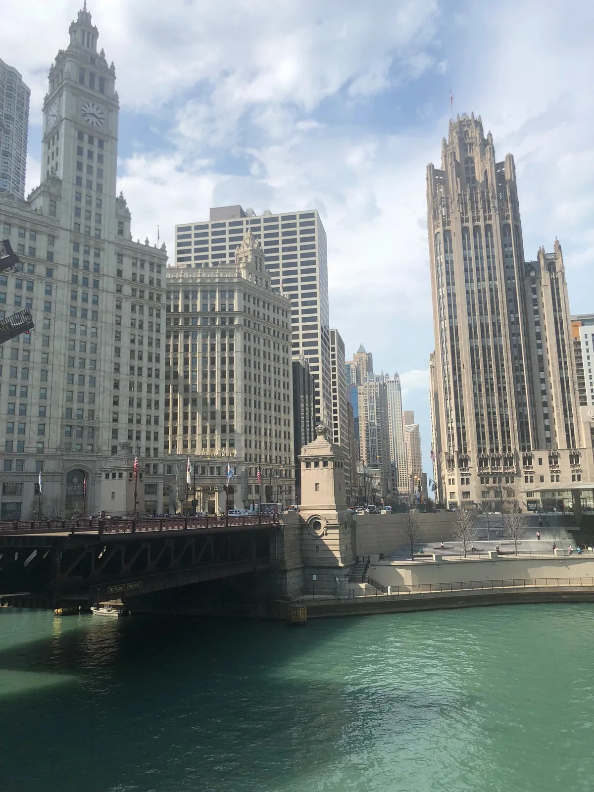 Chicago River with historic towers and a bridge under a blue sky